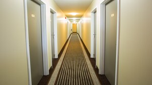 Un couloir d’hôtel avec des portes numérotées 20 et 30, donnant accès aux chambres.