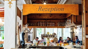 A bar area with a 'Rezeption' sign, wooden bar counter, and seating. - Landhotel Hirschen (Oberwolfach)