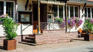 A traditional European hotel with a two-story facade, large windows, and flower boxes on the balconies. - Landhotel Hirschen (Oberwolfach)
