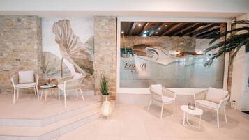 A modern interior with stone walls, a mural, and seating areas.