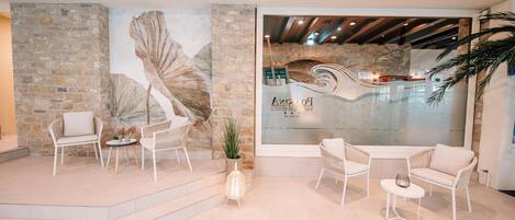 A modern interior with stone walls, a mural, and seating areas.