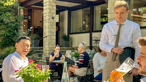A patio area with stone pillars, outdoor seating, and a person pouring a drink. - Best Western Hotel Polisina (Frickenhausen a. Main)