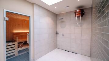 Un baño moderno con ducha, sauna de madera y un amplio ventanal.