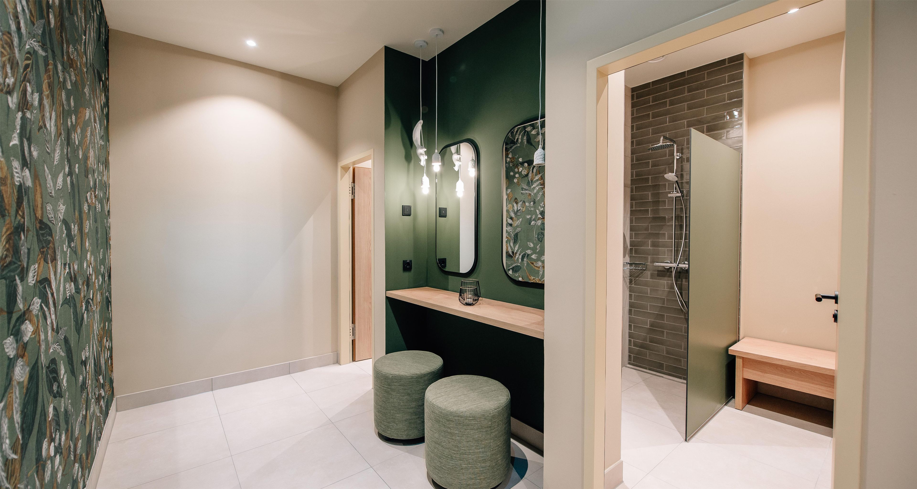 A modern bathroom with a mirror, vanity, and a shower area.