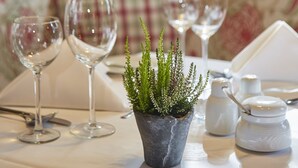 A dining table with three wine glasses, a small potted plant, salt and pepper shakers, and a white tablecloth. - Best Western Hotel Polisina (Frickenhausen a. Main)