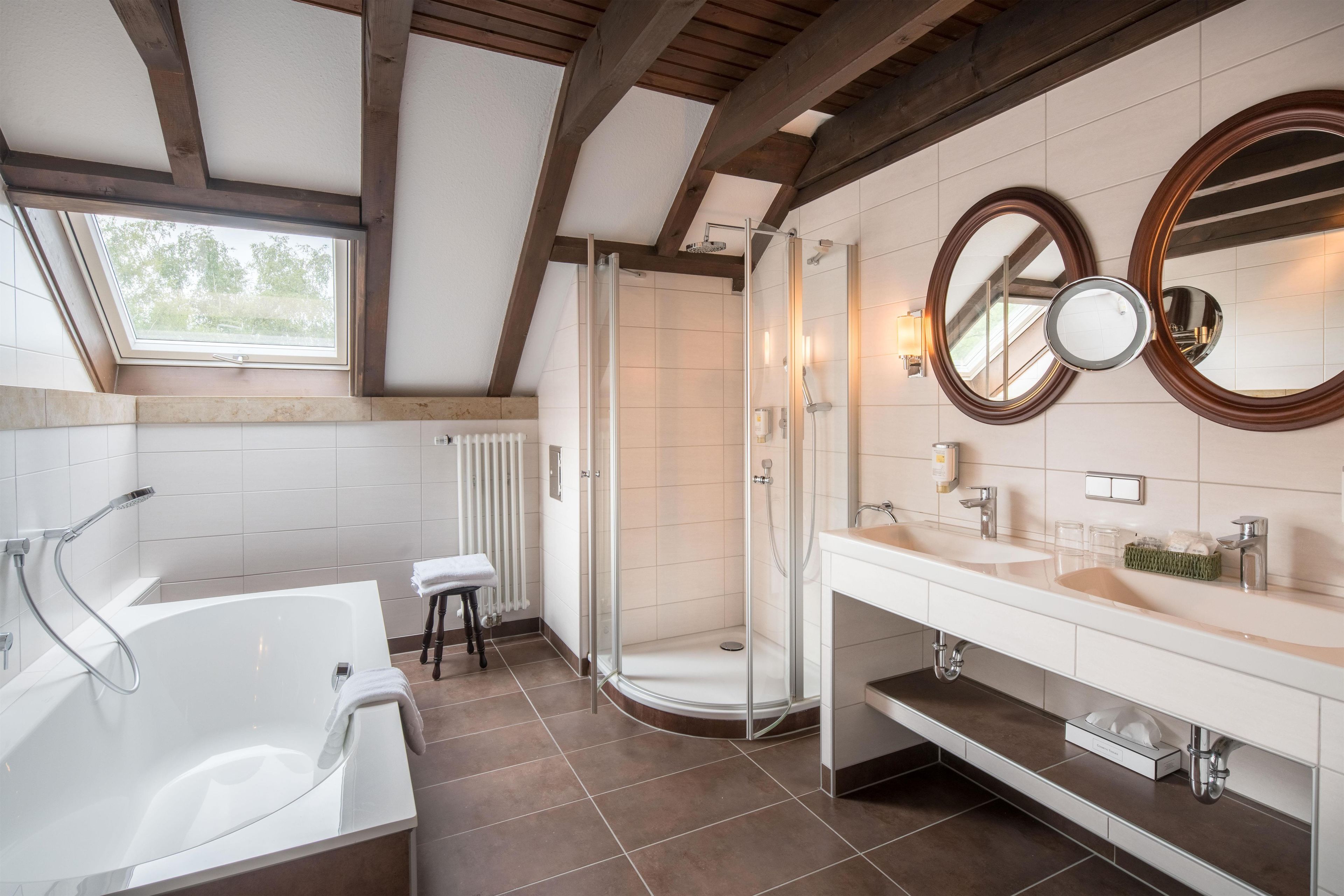 Ein modernes Badezimmer mit einer Badewanne, einer Dusche und zwei Waschbecken.