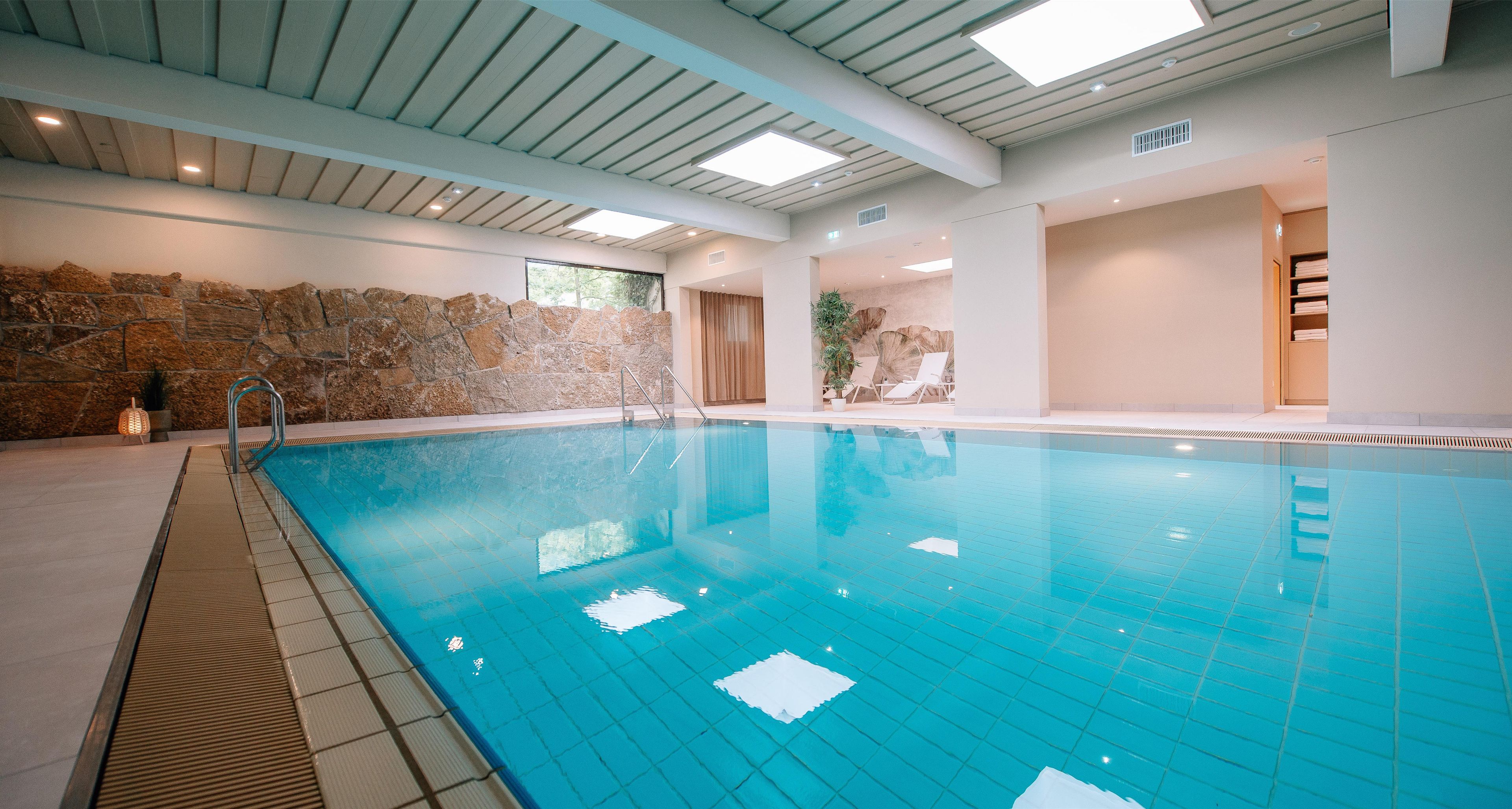 Una piscina techada, sillones reclinables de piscina