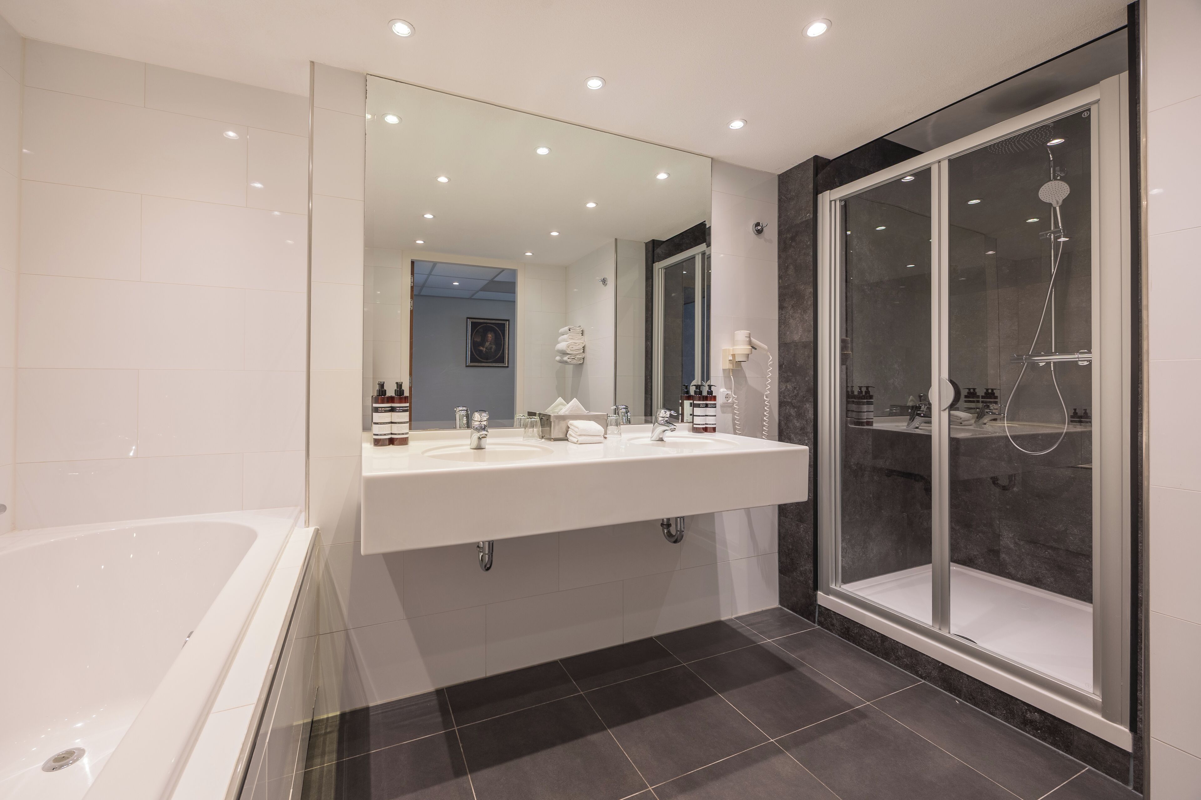 junior suite | bathroom | combined shower/bathtub, eco-friendly toiletries, hair dryer, towels