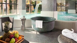 A spa area with a hot tub, a waterfall feature, and a fruit basket.
