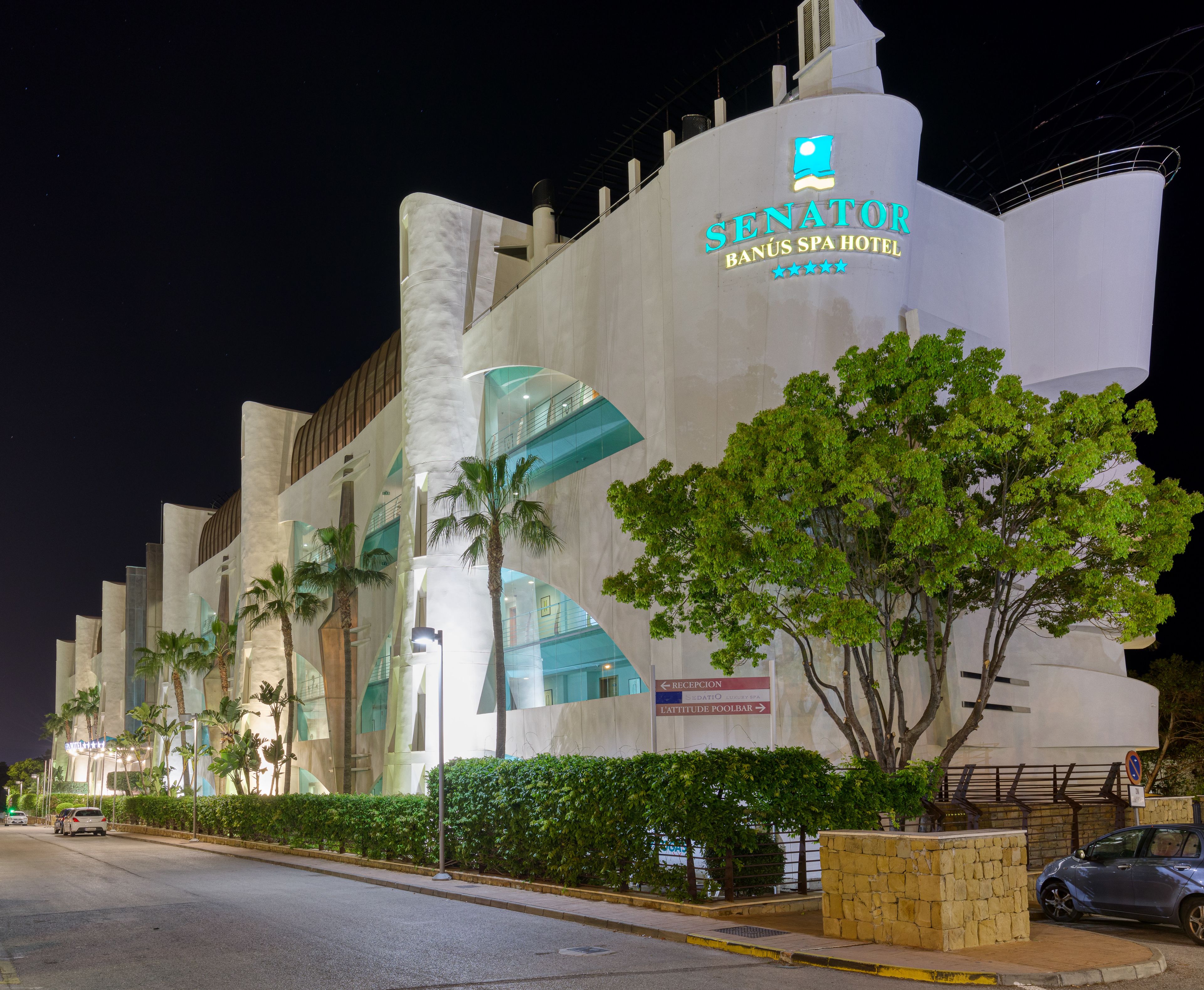 L’extérieur du Senator Banús Spa Hotel présente une architecture moderne, avec de grandes baies vitrées et des palmiers.