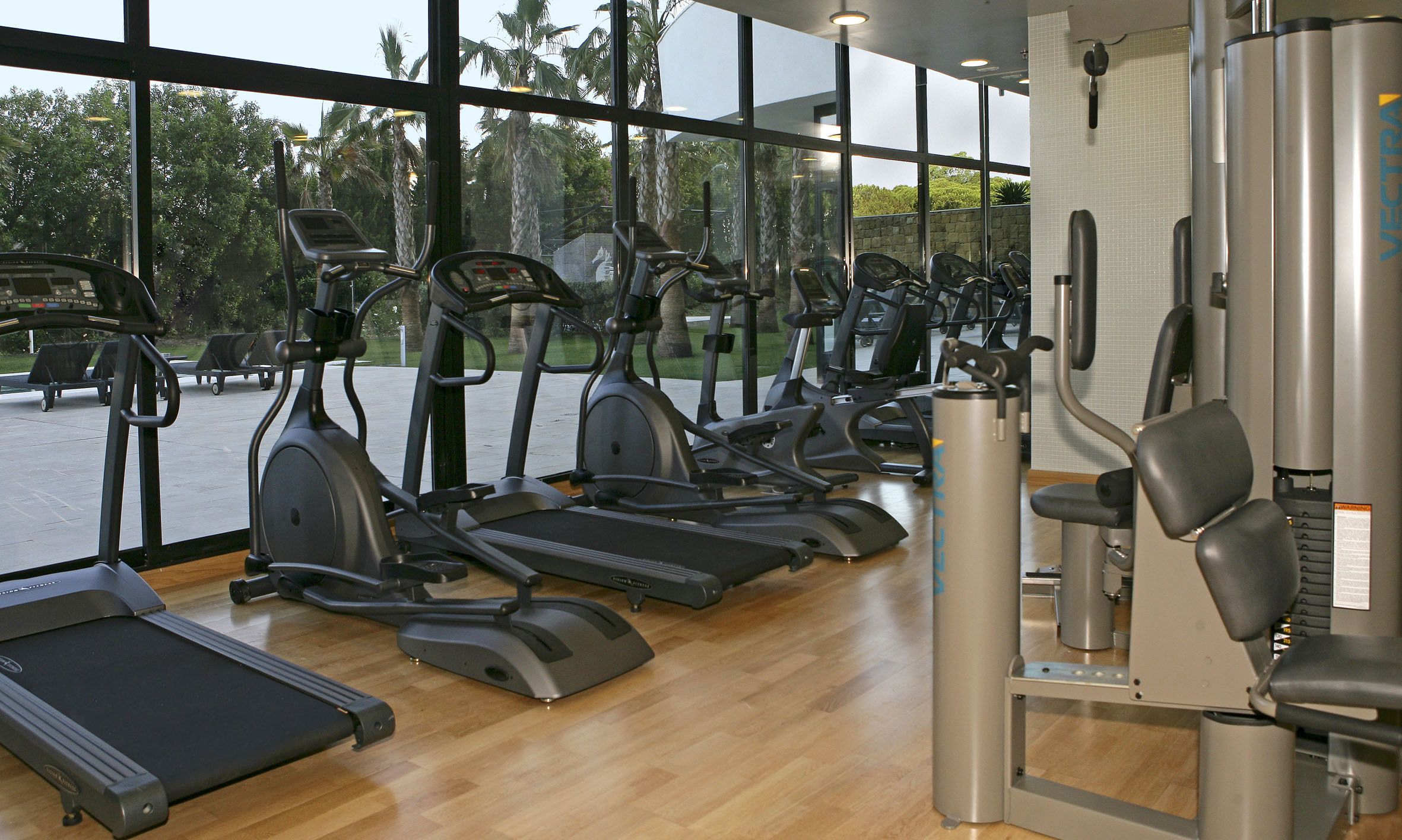 A gym with treadmills, elliptical machines, and weight equipment.