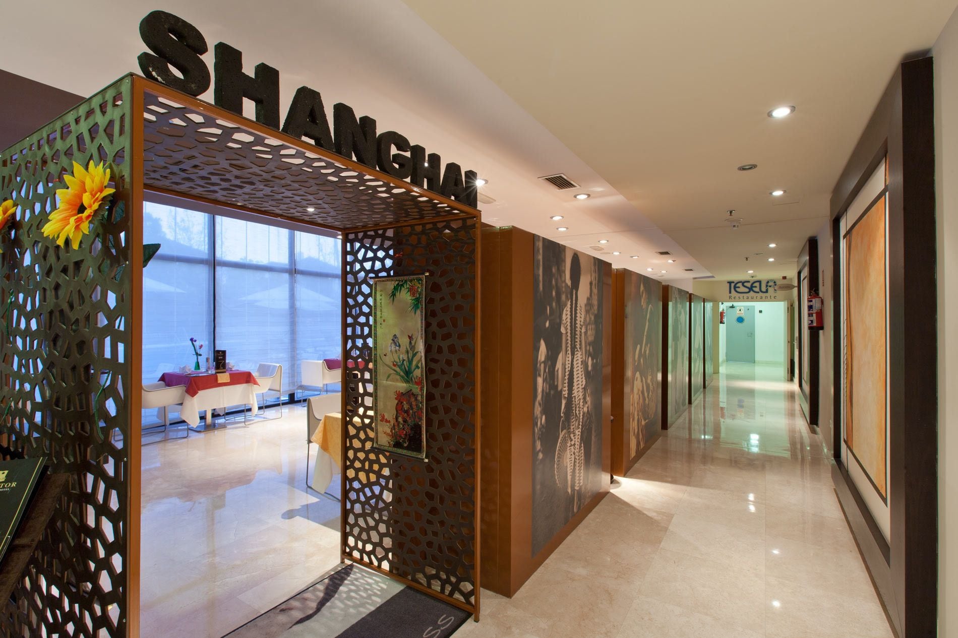A modern hotel corridor with a decorative entrance labeled "SHANGHAI".
