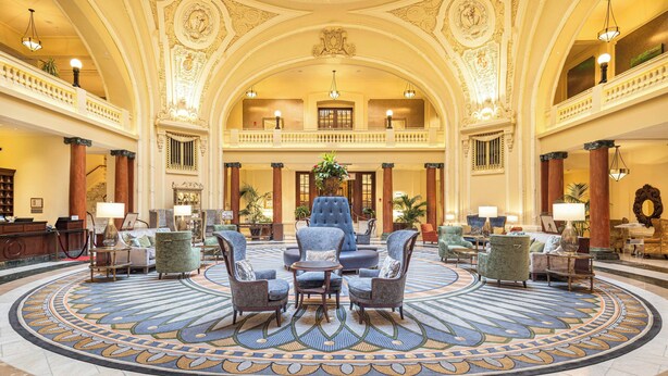 A grand lobby with a central seating area, ornate ceiling, and a large chandelier. - The Battle House Renaissance Mobile Hotel & Spa (Mobile)