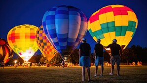 Ein nächtliches Heißluftballonfestival mit zahlreichen Ballons in verschiedenen Farben.