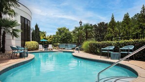 Ein Swimmingpool mit Liegestühlen und einer Lampe.