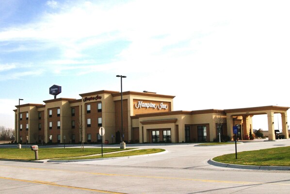 A Hampton Inn hotel with a large entrance, multiple floors, and a parking lot.