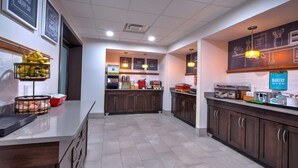 Una cocina moderna con una isla central, una zona de panadería y una barra para desayunar.