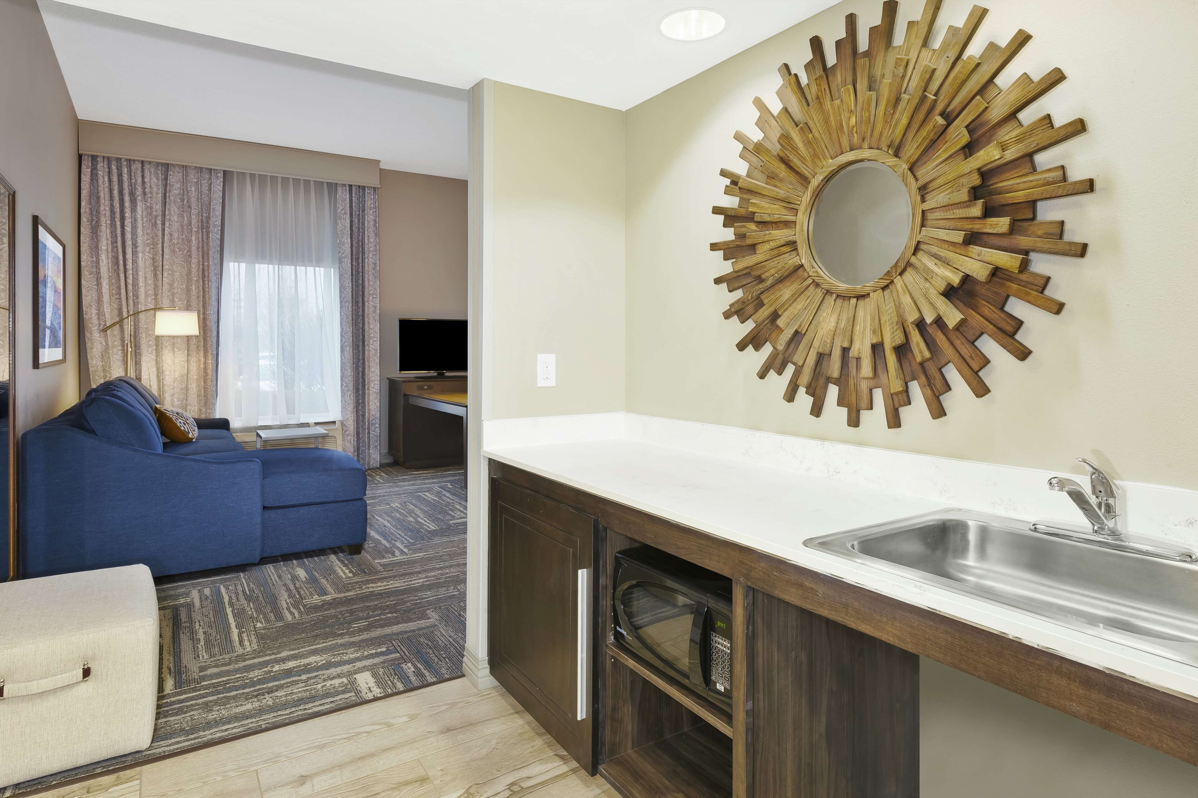 Una cucina moderna con lavello integrato e un pannello decorativo in legno.
