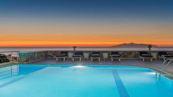 Een binnenzwembad, een buitenzwembad en parasols bij het zwembad