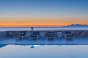 Una piscina techada, una piscina al aire libre, sombrillas