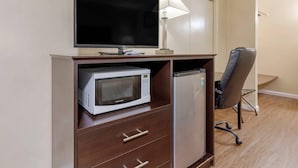Eine Küchenzeile mit Mikrowelle, Kühlschrank und einem Flachbildfernseher auf einem Holzkabinent.
