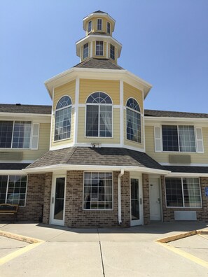 A two-story building with a central tower, large windows, and a brick facade.