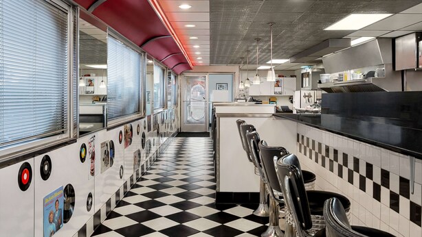 A diner with a checkered floor, vinyl record wall decor, and a jukebox. - Baymont by Wyndham Rawlins (Rawlins)
