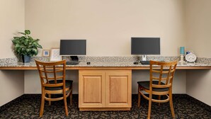 A workspace with two chairs, a desk, two monitors, a plant, and a clock. - Baymont by Wyndham Rawlins (Rawlins)