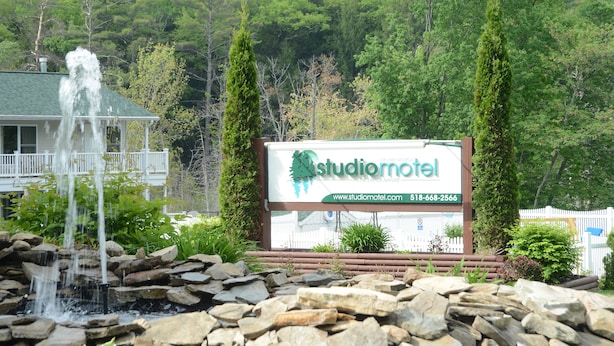 Señal de Studiomotel con una cascada al frente.