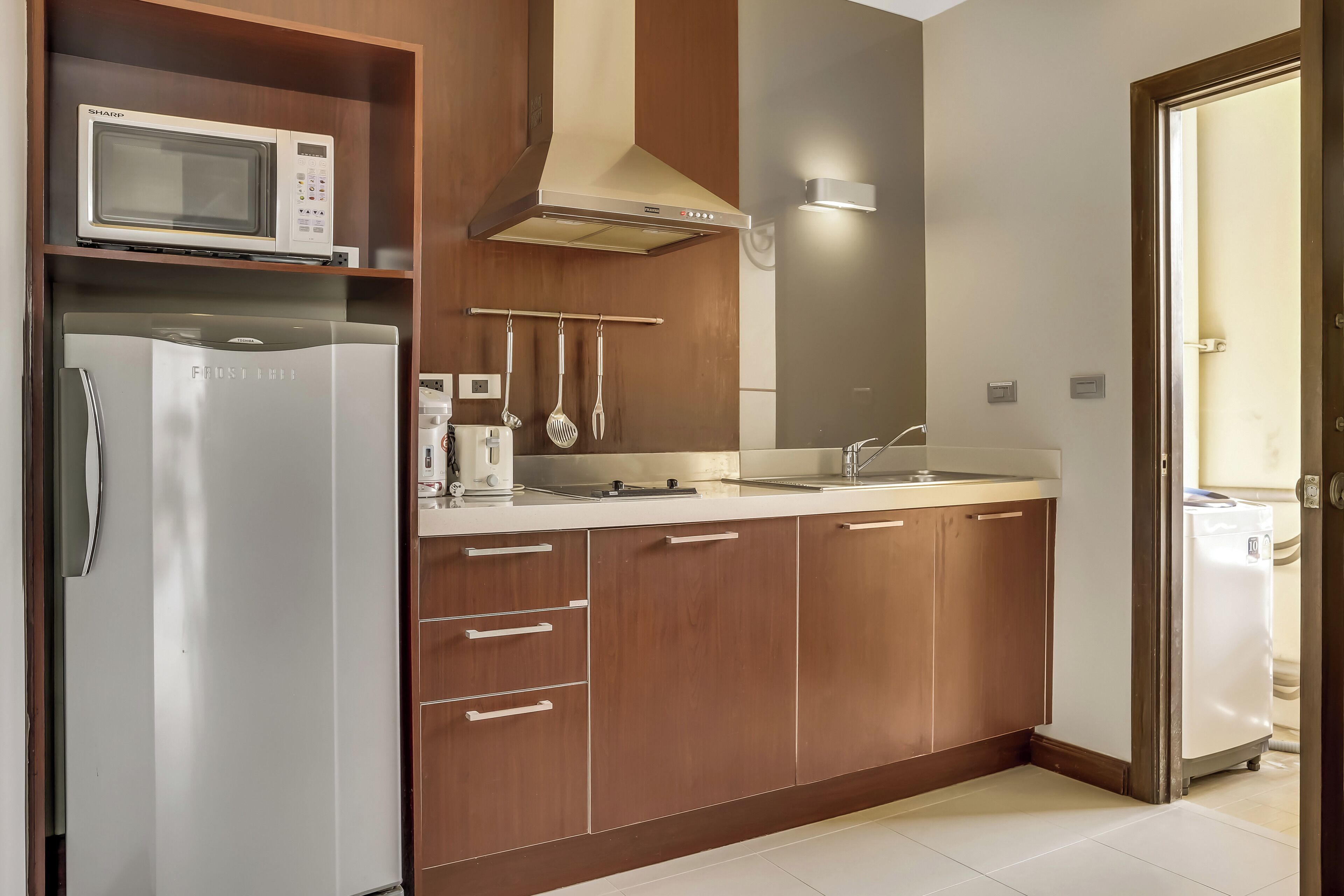 A compact kitchen with a microwave, refrigerator, and sink.