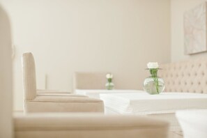A hotel room with a bed, a chair, and a vase with a flower. - Banksia Boutique (Cape Town)