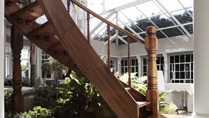 A wooden staircase leading to a glass-enclosed area with a hot tub.