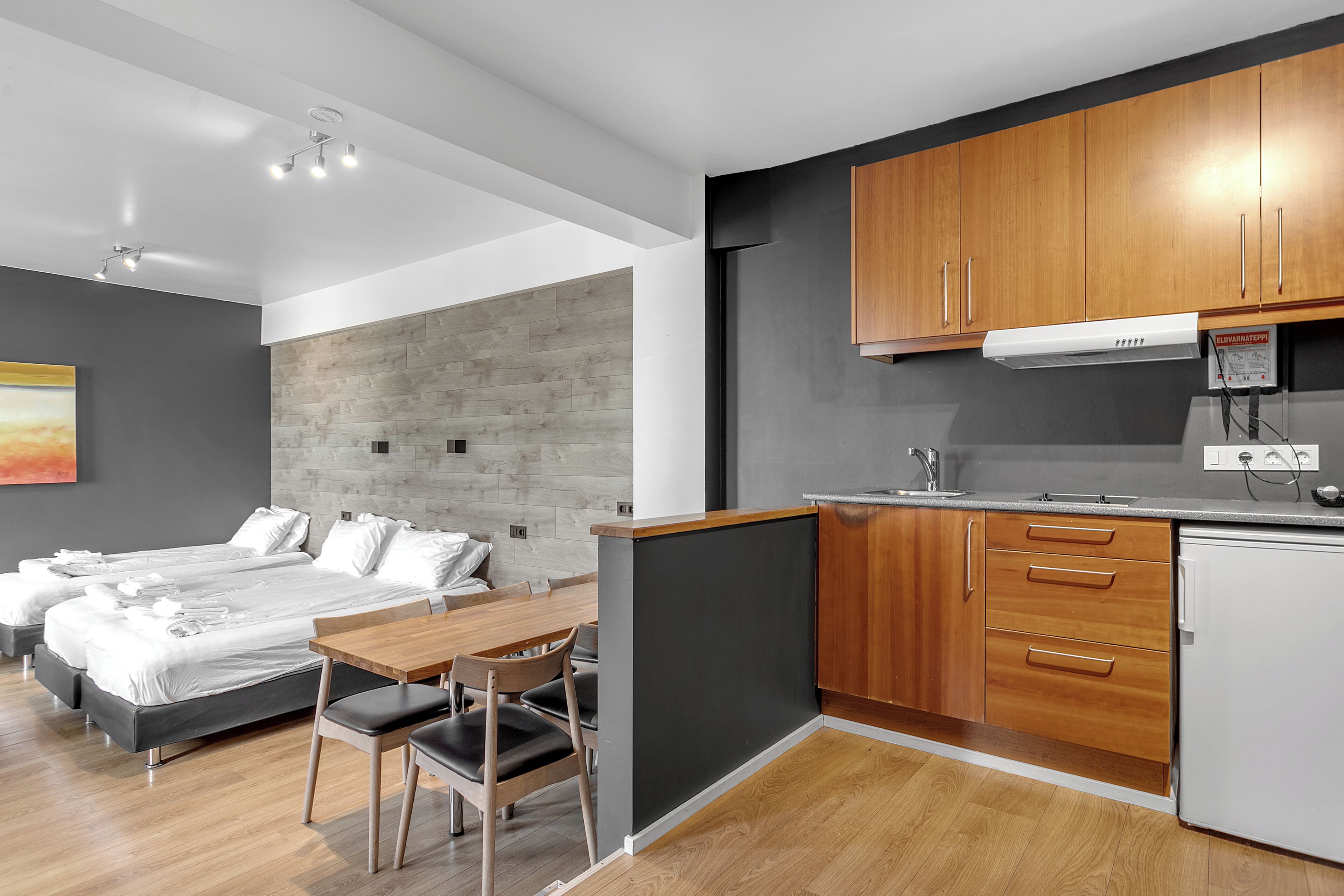 Une chambre d’hôtel moderne dotée d’un grand lit, d’une table à manger et d’une kitchenette.
