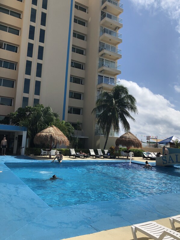 Una piscina al aire libre, sombrillas