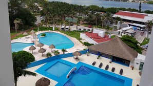 Ein Resort mit zwei Schwimmbecken, einem Strandbereich und Meerblick.