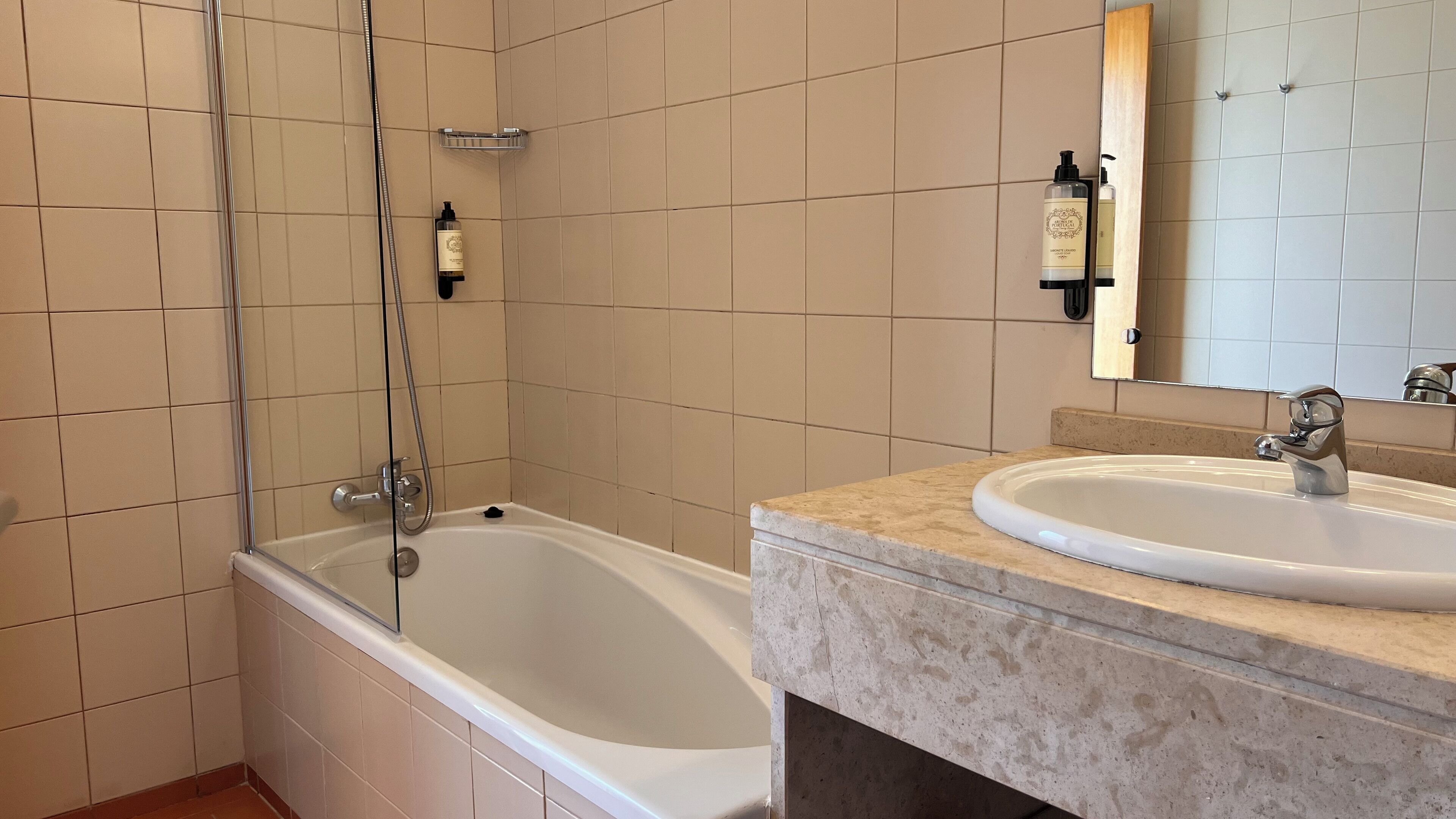 Un baño con bañera, lavamanos y espejo.