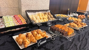 A buffet table with various baked goods including bread, croissants, and pastries. - Flag Hotel Barcelos (Barcelos)