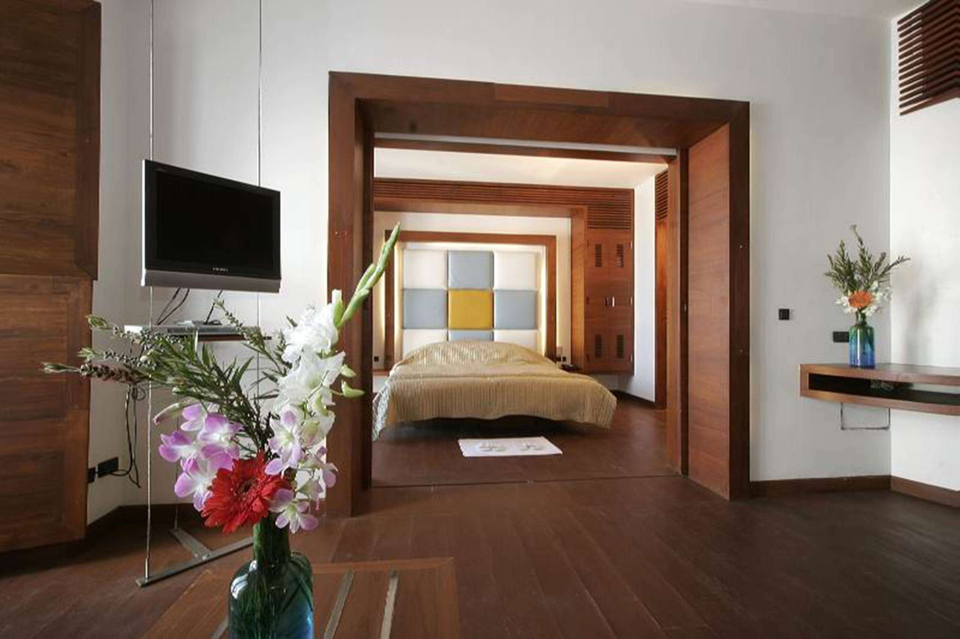 Ein modernes Hotelzimmer mit einem Bett, einem Flachbildfernseher und Holzboden.