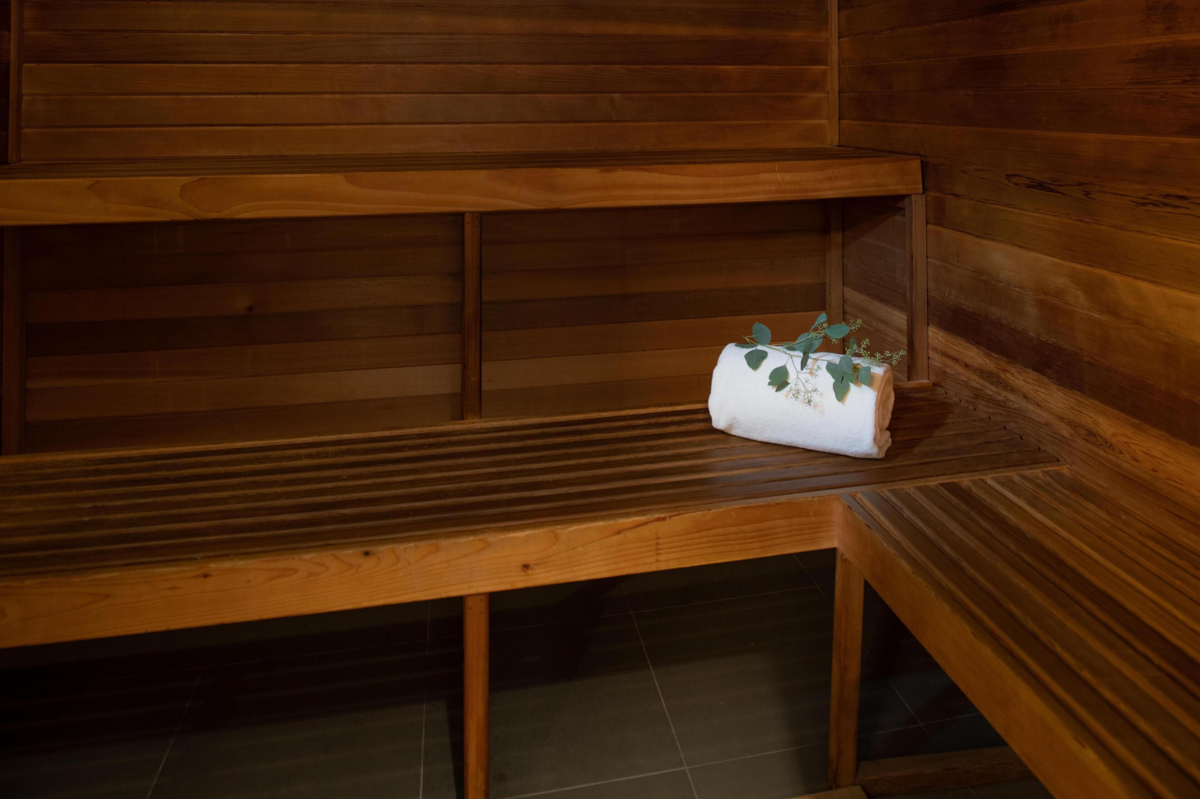 A wooden bench with a towel and a small plant.