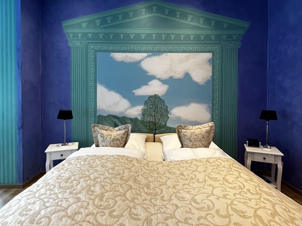 A bedroom with a large bed, two nightstands, and a mural of a tree and sky. - PARK VILLA zentral am Mittelrhein (Boppard)