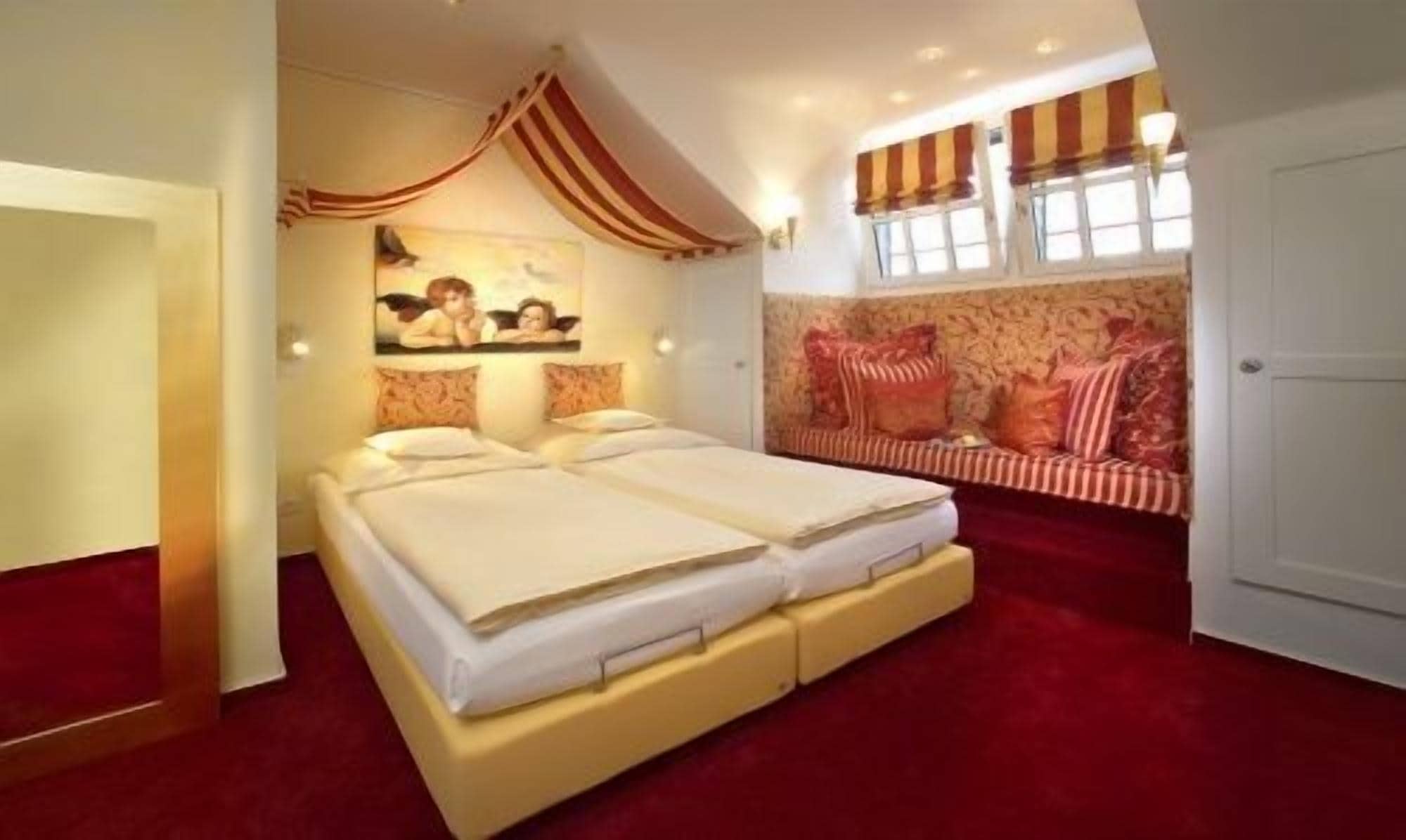 Una habitación de hotel con una cama doble, un sofá y un cuadro en la pared.