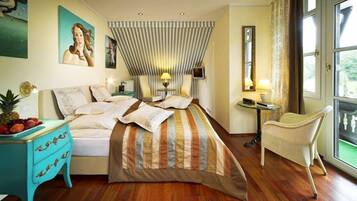 A bedroom with a bed, a small table with a lamp, a chair, and a fruit basket.
