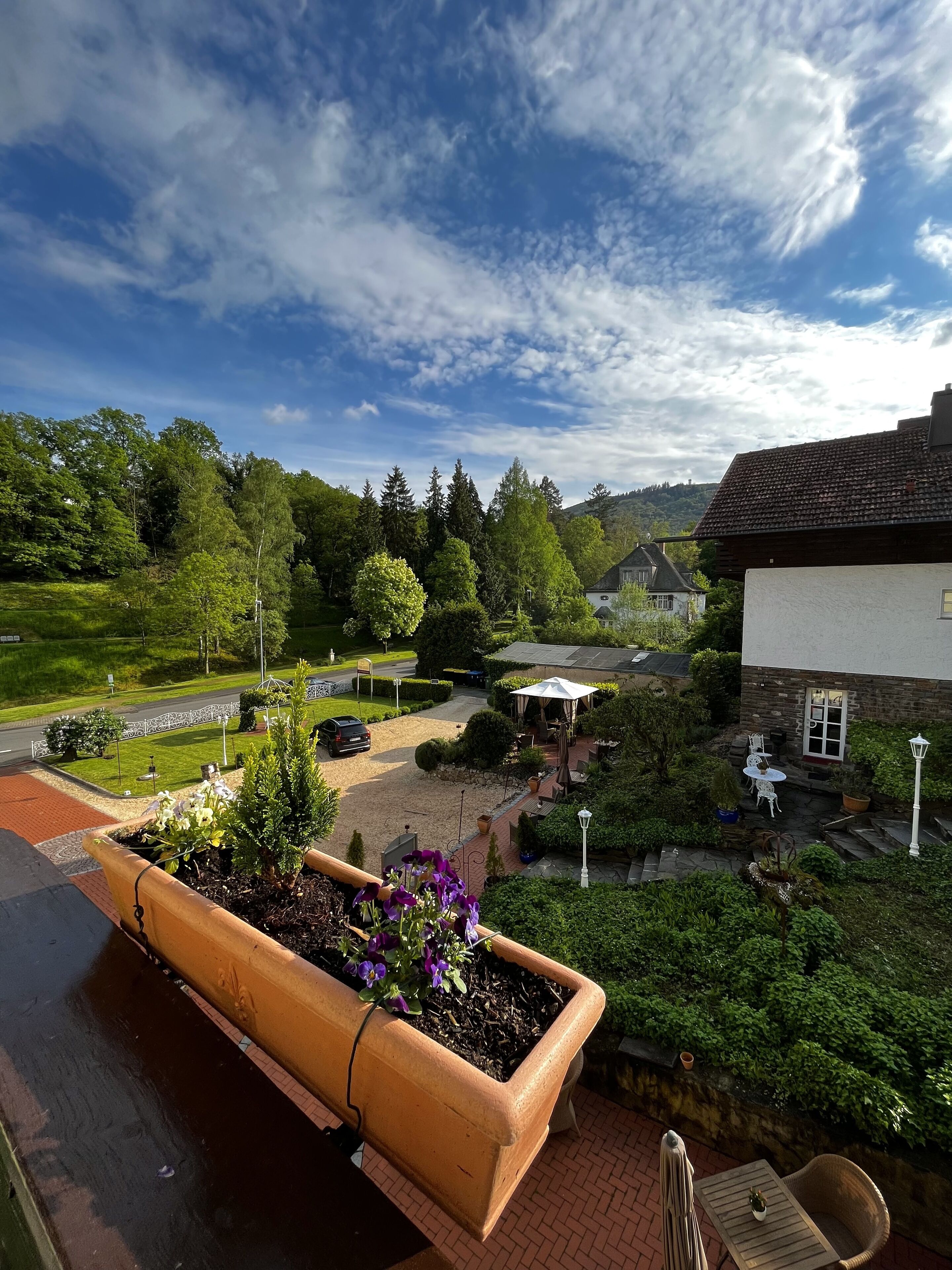 A garden with a large planter, a gazebo, and a building with outdoor seating.