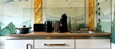 Una cocina de diseño moderno, con salpicadero de mármol, un ventanal grande y un microondas integrado.