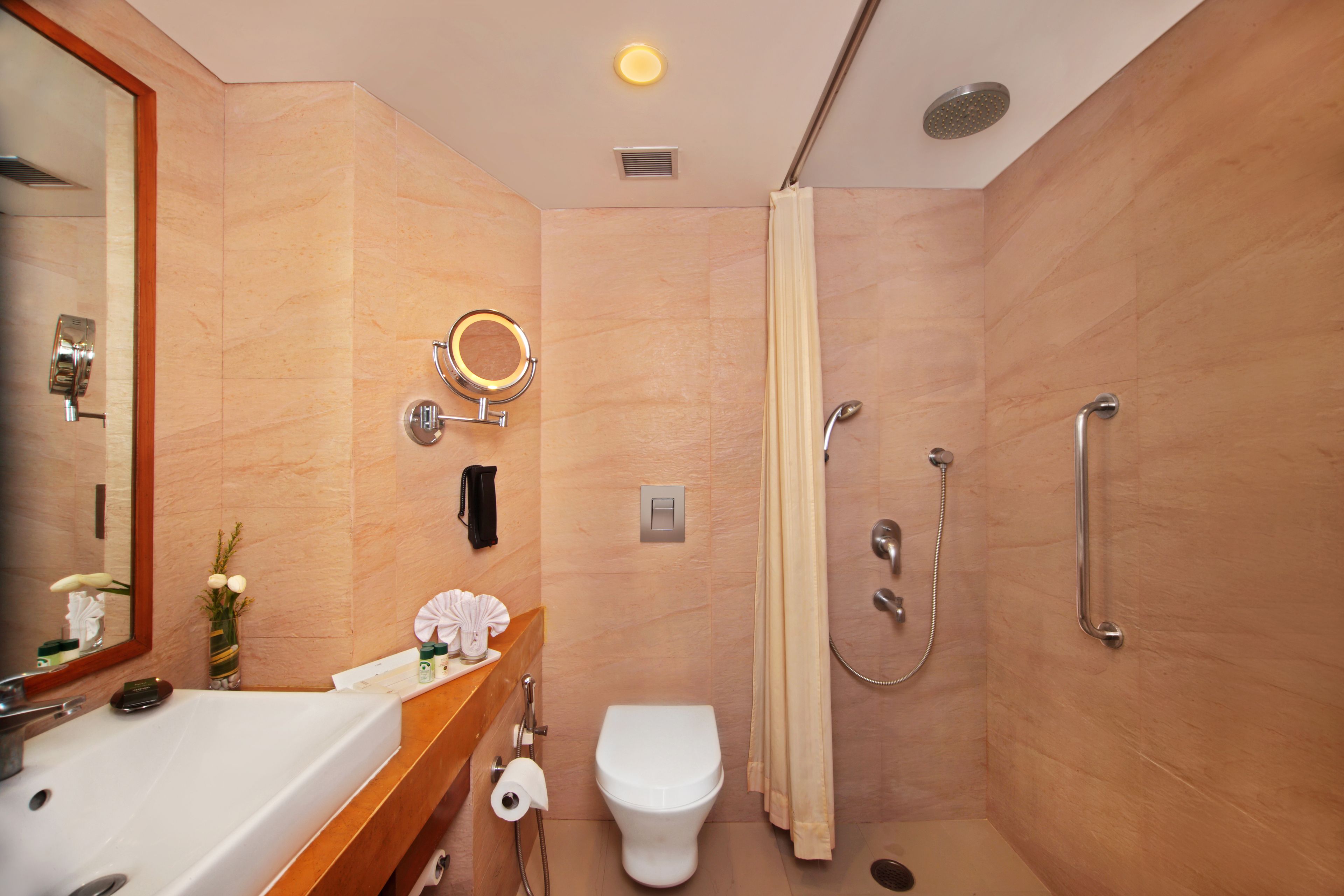 Un baño moderno con lavamanos, inodoro y ducha.
