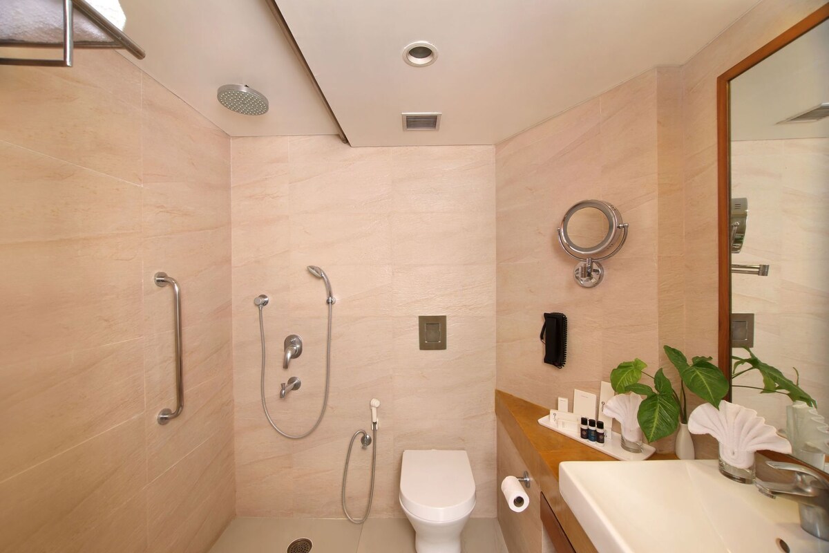 A modern bathroom with a shower, toilet, and sink.