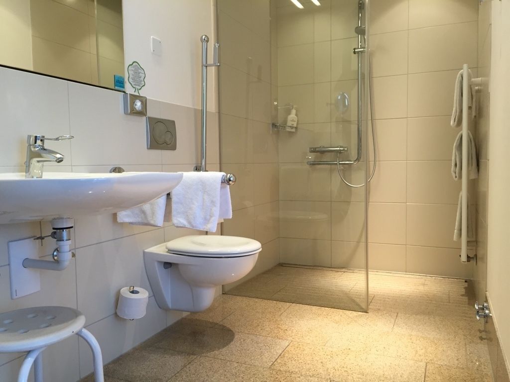 A modern bathroom with a sink, toilet, and glass-enclosed shower.