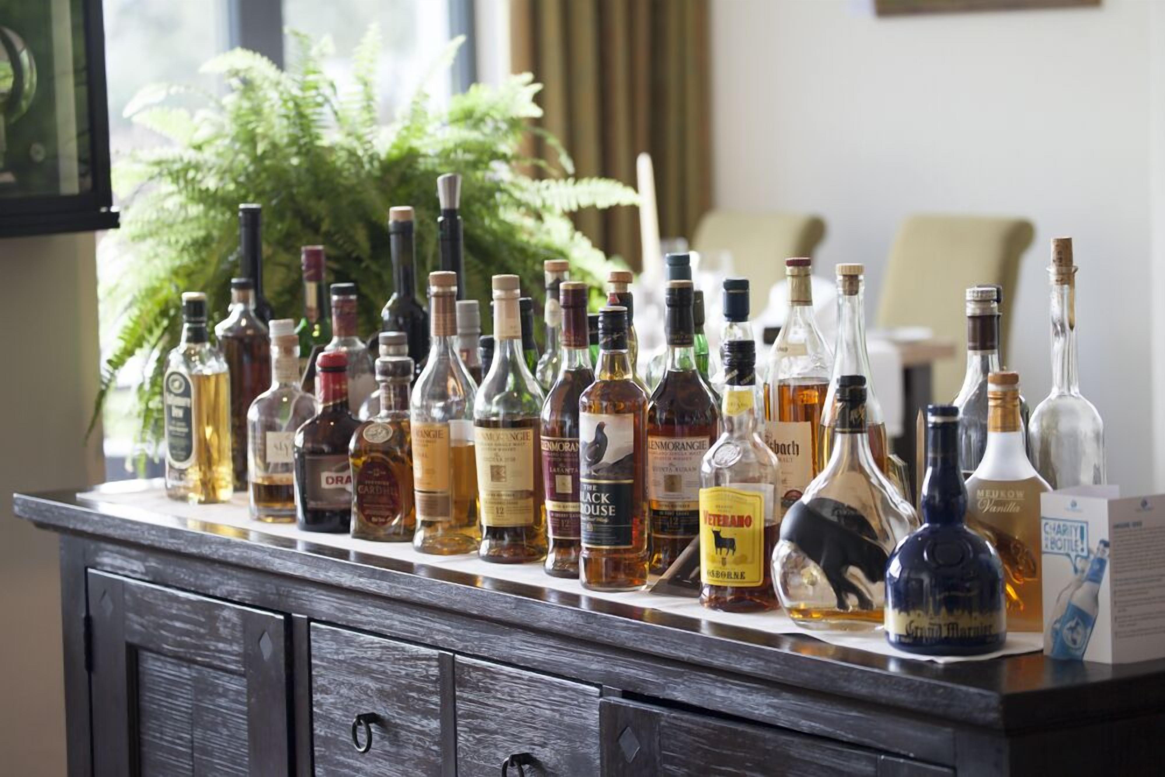 Un comptoir de bar avec différentes bouteilles d’alcool.