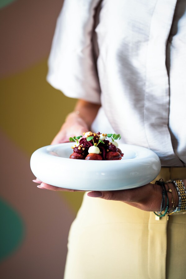 Una persona sosteniendo un plato blanco con un guiso.
