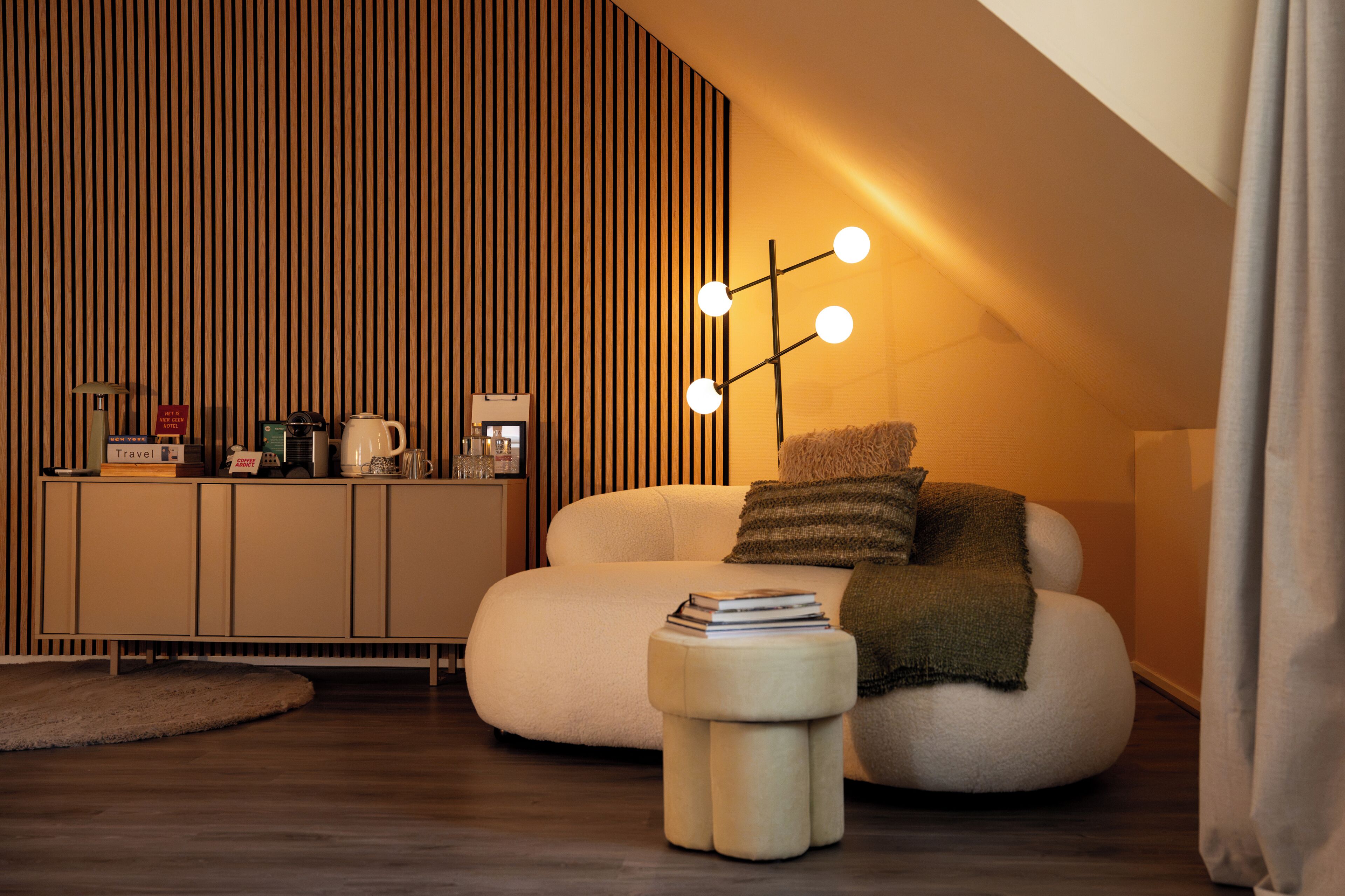 A modern living room with a sofa, a coffee table, a cabinet, and a wall-mounted light fixture.